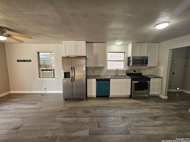 kitchen featuring ceiling fan, appliances with stainless steel finishes, sink, white cabinets, and a textured ceiling