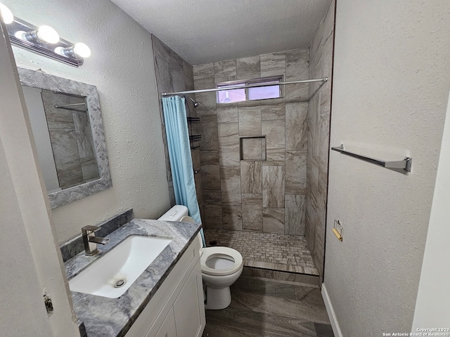 bathroom featuring toilet, a shower with shower curtain, a textured ceiling, vanity, and hardwood / wood-style floors