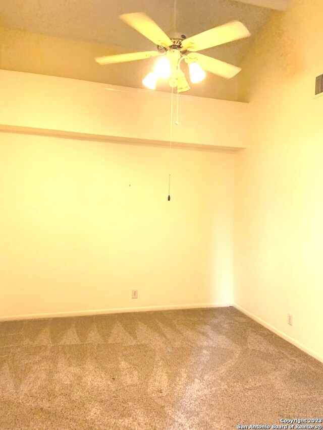 carpeted spare room with ceiling fan