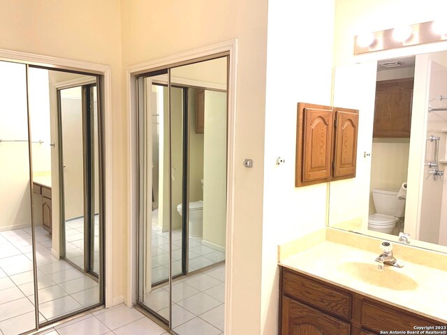bathroom with tile floors, toilet, and vanity