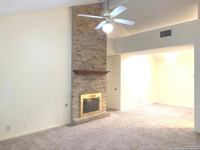 unfurnished living room with brick wall, a brick fireplace, ceiling fan, carpet, and lofted ceiling