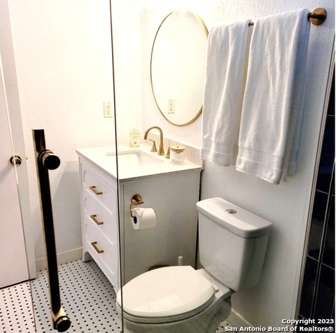 bathroom with vanity, tile floors, and toilet