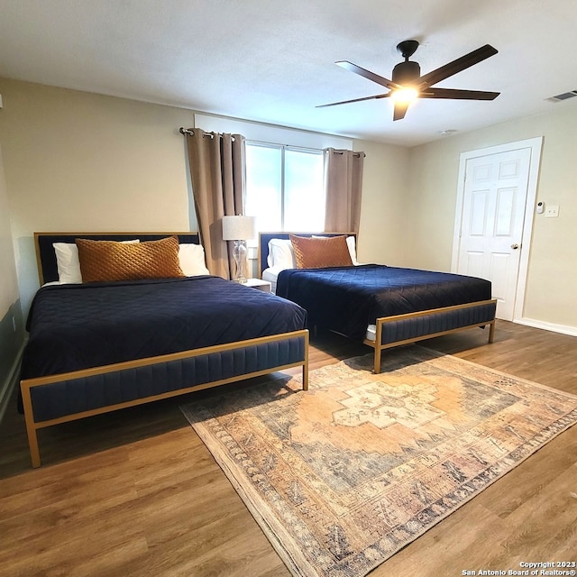bedroom with wood-type flooring and ceiling fan