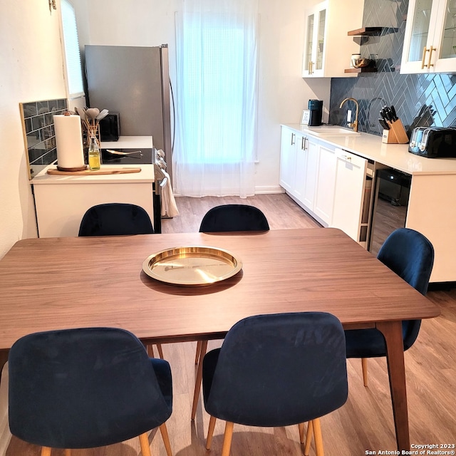 dining area with sink and light wood-type flooring