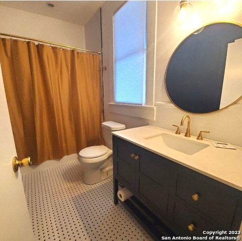 bathroom featuring toilet and vanity with extensive cabinet space