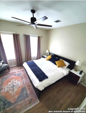 bedroom with ceiling fan and dark hardwood / wood-style floors