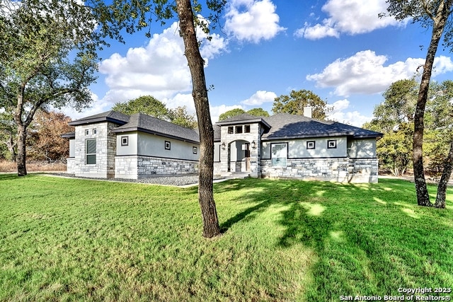 rear view of house featuring a lawn