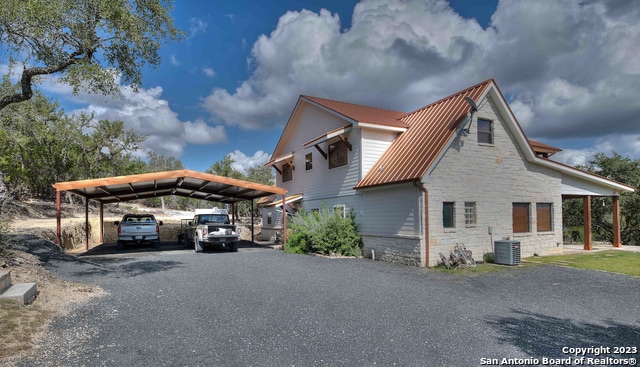 view of side of home featuring cooling unit and a carport