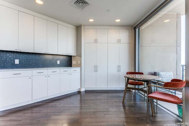 kitchen featuring backsplash, dark wood-type flooring, and white cabinets