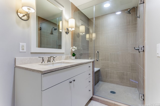 bathroom featuring vanity and a shower with door