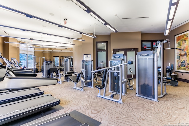 gym with french doors and light colored carpet