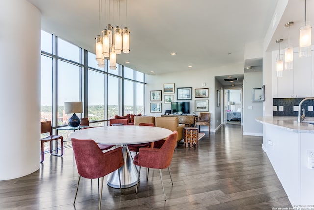 dining area featuring sink, a notable chandelier, floor to ceiling windows, and dark hardwood / wood-style flooring