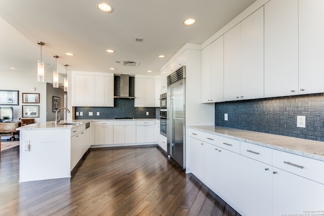 kitchen featuring dark hardwood / wood-style flooring, tasteful backsplash, wall chimney exhaust hood, and white cabinets