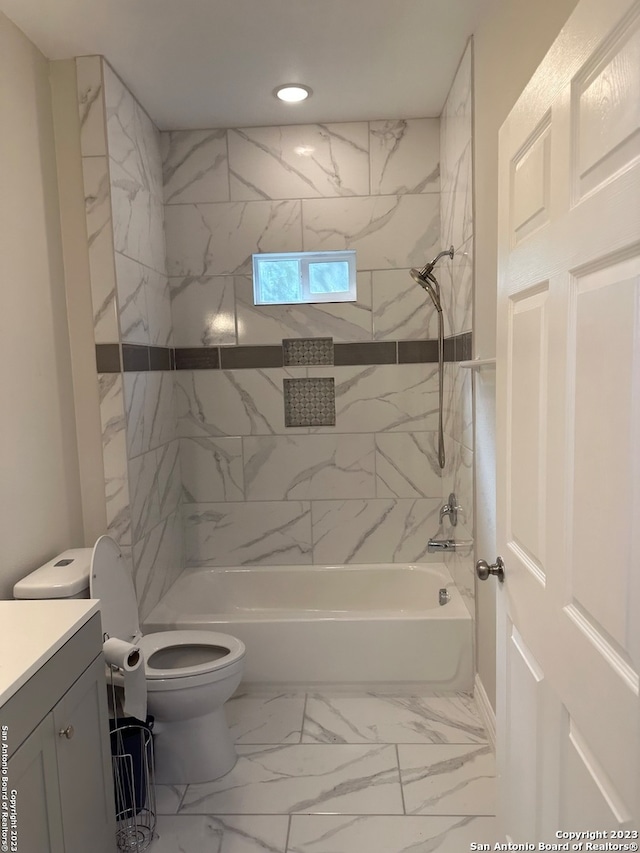 full bathroom with toilet, vanity, tiled shower / bath combo, and tile floors