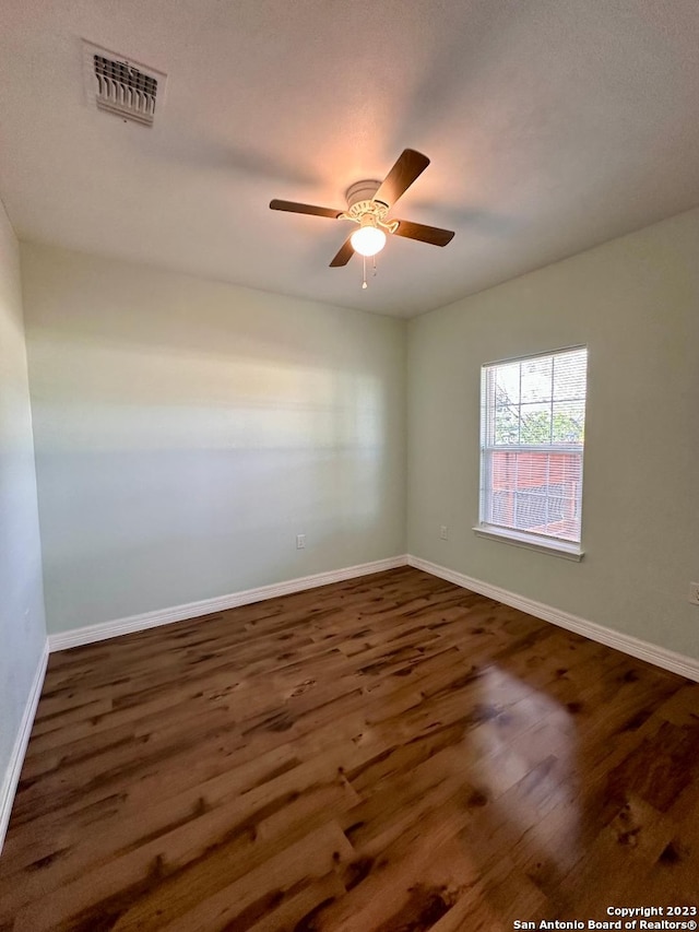 spare room featuring dark wood-type flooring and ceiling fan