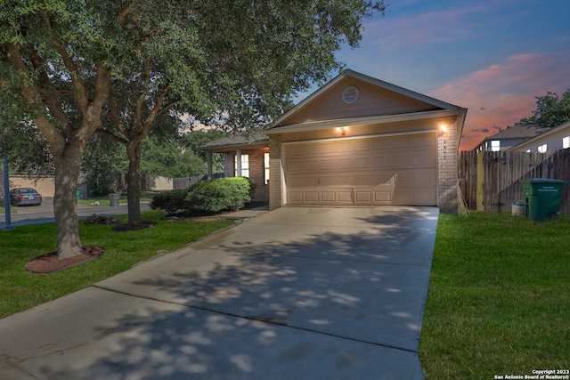 view of front of home with a garage and a lawn