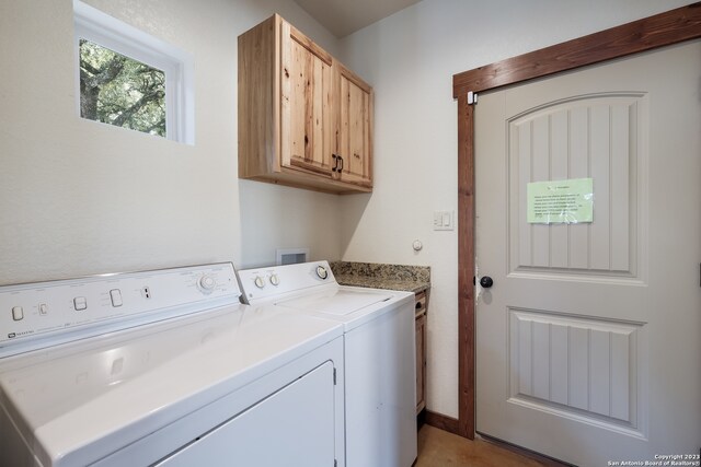 washroom with washing machine and clothes dryer and cabinets