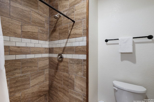 bathroom with toilet and tiled shower