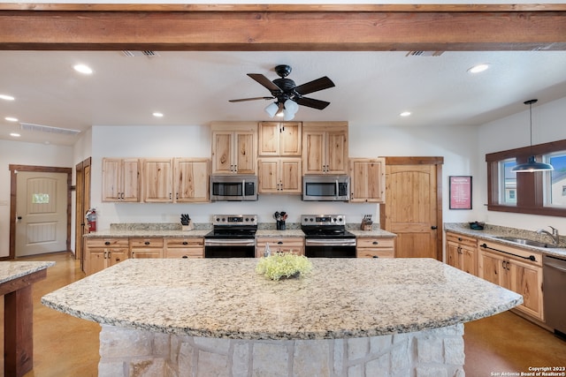 kitchen with hanging light fixtures, ceiling fan, appliances with stainless steel finishes, and light stone counters