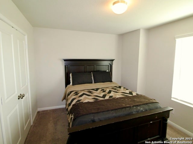 bedroom with dark colored carpet