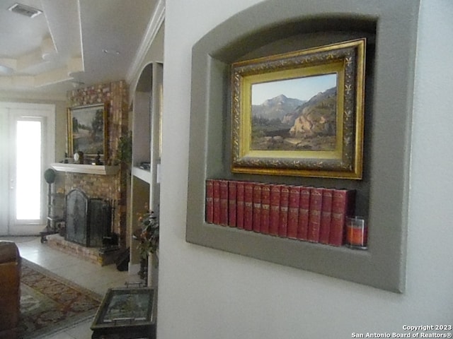 interior details with crown molding and a brick fireplace