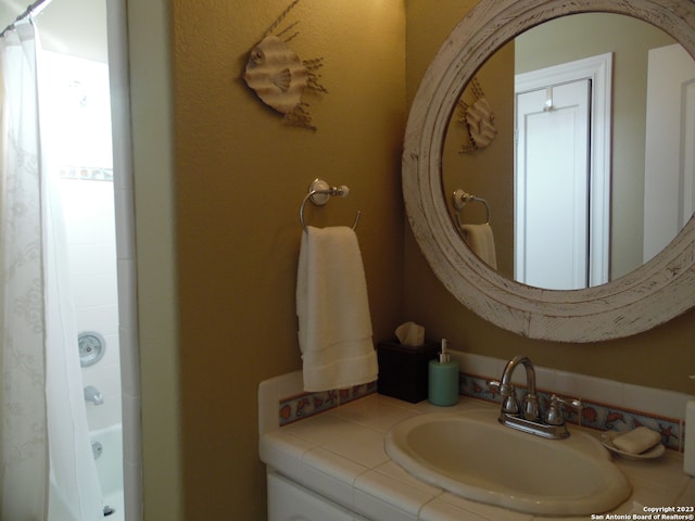 bathroom featuring shower / bath combo with shower curtain and vanity