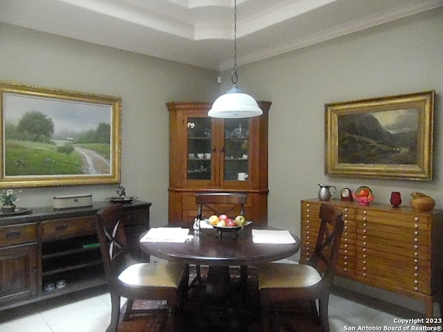 dining area featuring a raised ceiling and ornamental molding