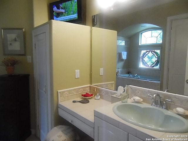 bathroom with a washtub and vanity