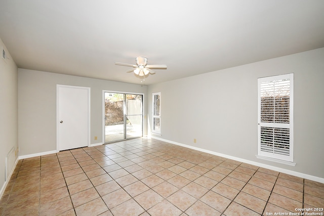 tiled spare room featuring ceiling fan