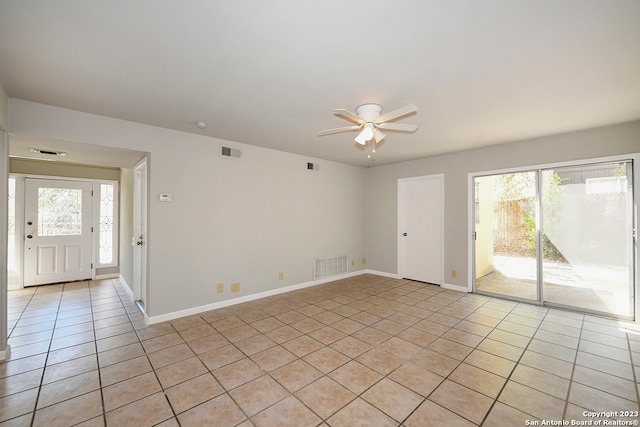 spare room with ceiling fan and light tile floors