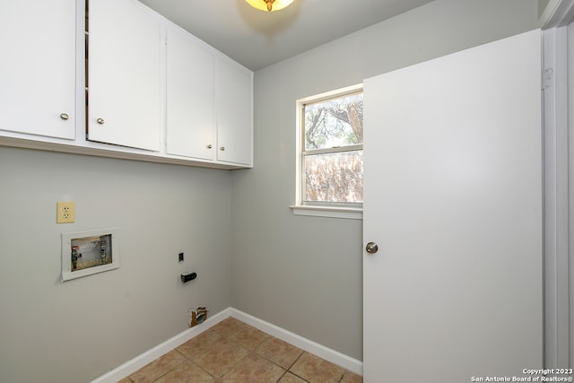 clothes washing area with cabinets, light tile floors, and hookup for a washing machine