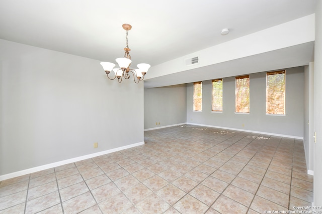 tiled empty room with a chandelier