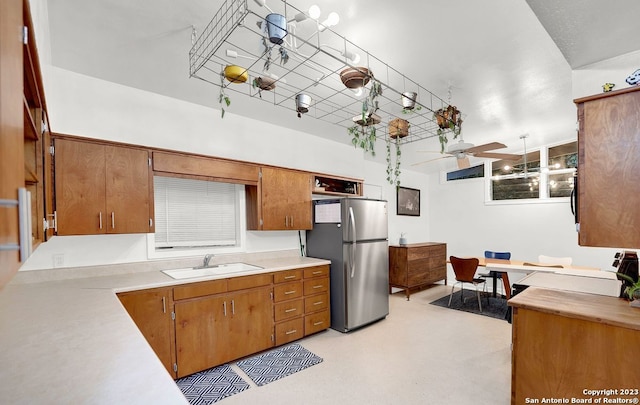 kitchen featuring stainless steel fridge, ceiling fan with notable chandelier, and sink