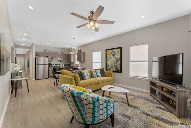 living room with light hardwood / wood-style floors and ceiling fan