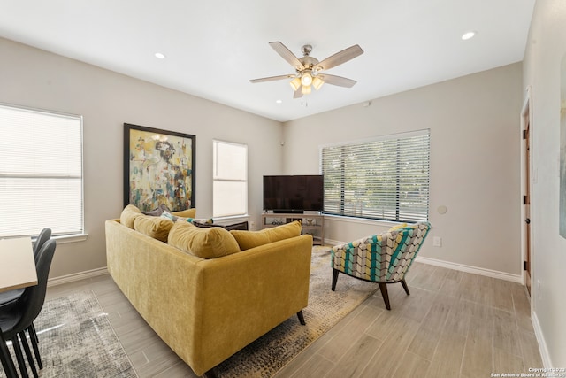 living room with light hardwood / wood-style floors and ceiling fan