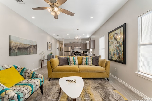 living room featuring light hardwood / wood-style floors, ceiling fan, and a wealth of natural light