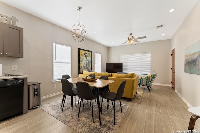 dining room with light hardwood / wood-style floors and ceiling fan with notable chandelier