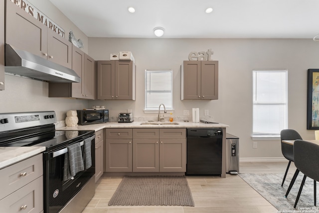 kitchen featuring gray cabinetry, sink, a wealth of natural light, and black appliances