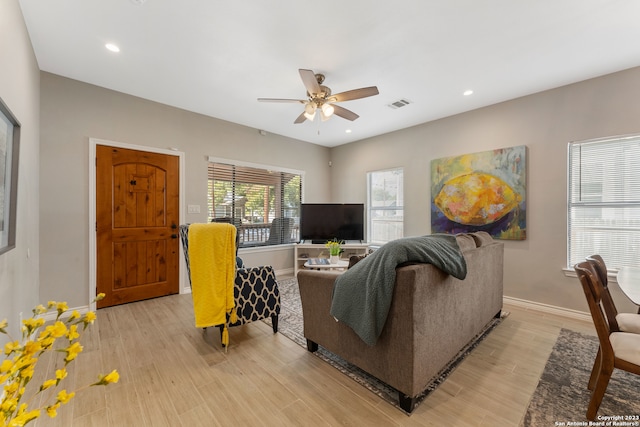 living room with ceiling fan and light hardwood / wood-style flooring