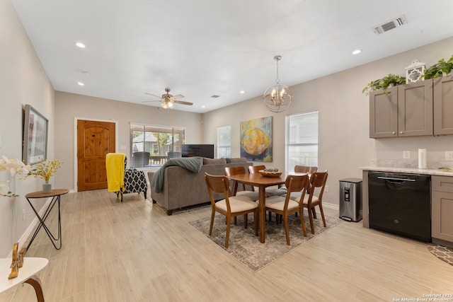 dining room with light hardwood / wood-style floors and ceiling fan with notable chandelier