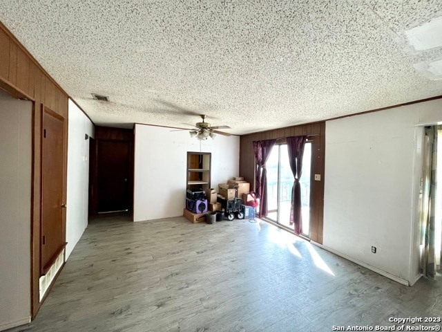 spare room with ceiling fan, a textured ceiling, and wood-type flooring