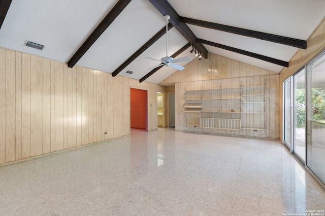 unfurnished living room with wood walls and beam ceiling