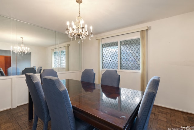 dining room featuring plenty of natural light, an inviting chandelier, and dark parquet floors