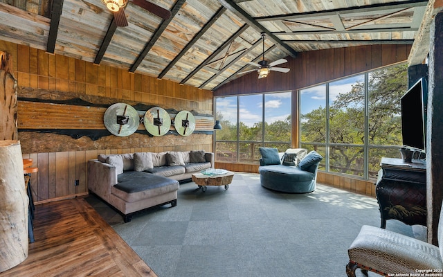 living room featuring ceiling fan, wood walls, and wooden ceiling