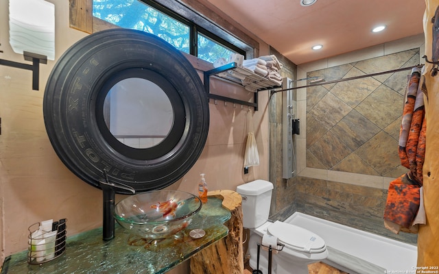 full bathroom with tiled shower / bath combo, toilet, and sink