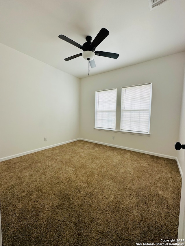 carpeted spare room with ceiling fan