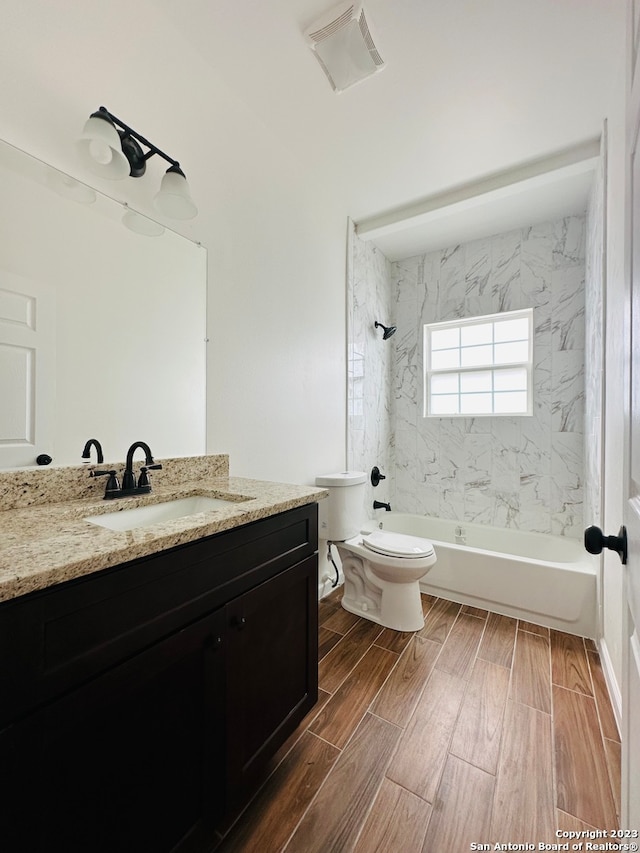 full bathroom with vanity, tiled shower / bath, and toilet