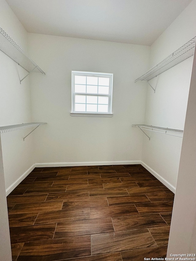 walk in closet with dark wood-type flooring