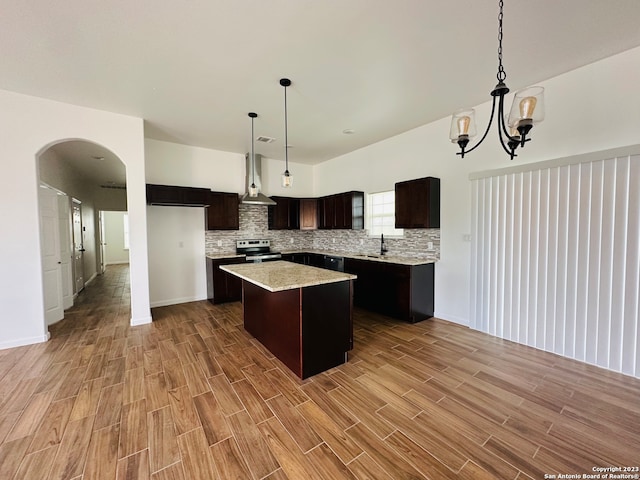 kitchen with stainless steel electric stove, backsplash, a kitchen island, decorative light fixtures, and dark brown cabinetry