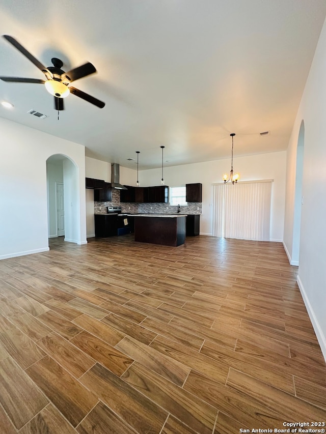 unfurnished living room with ceiling fan with notable chandelier